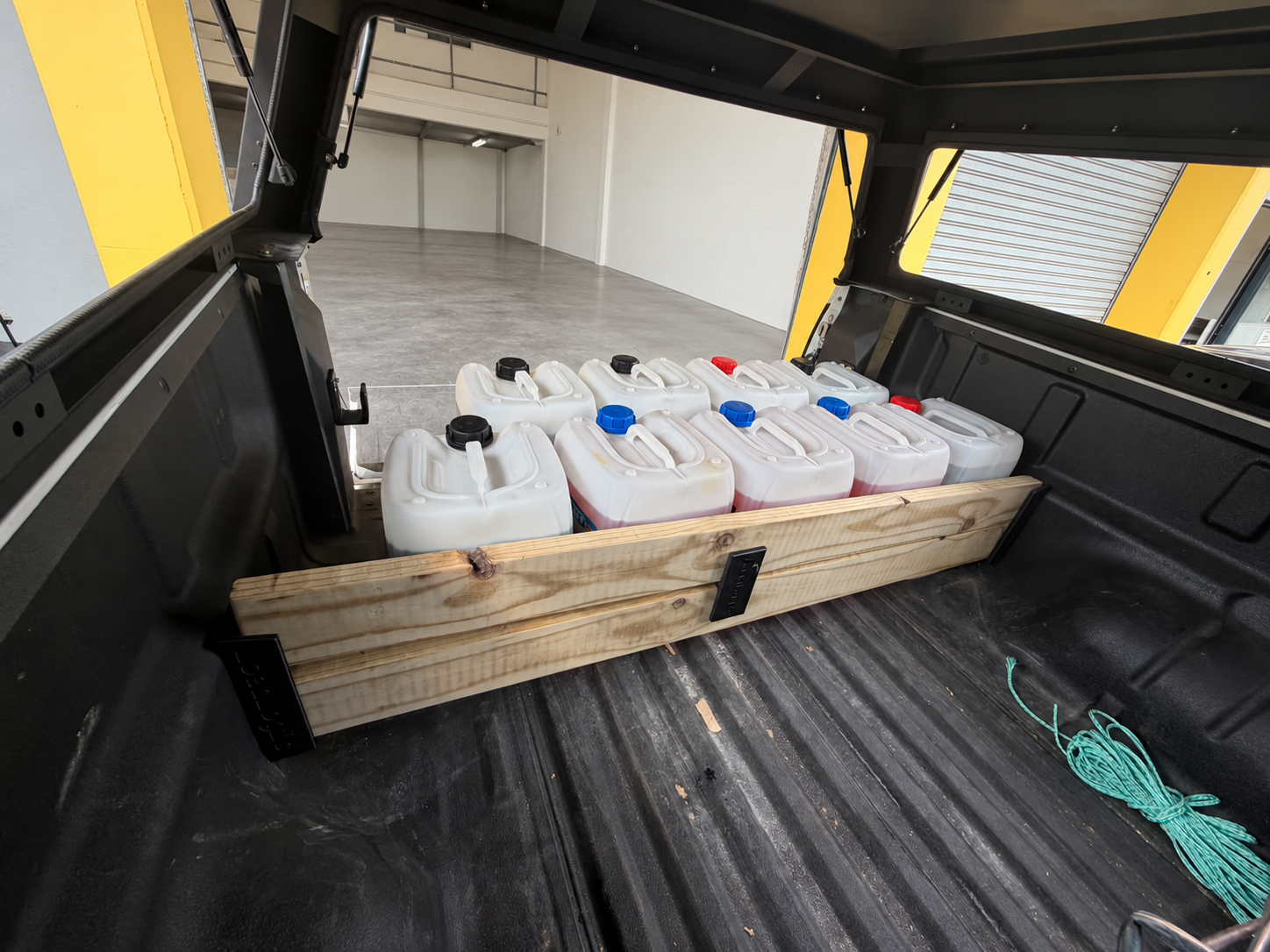 LoadLogic Max divider with two planks and a centre brace organising a bakkie load bin